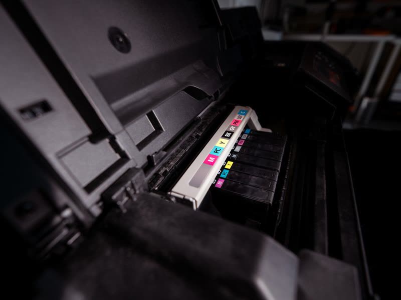 Interior de una impresora abierta con sus cartuchos de tinta de colores